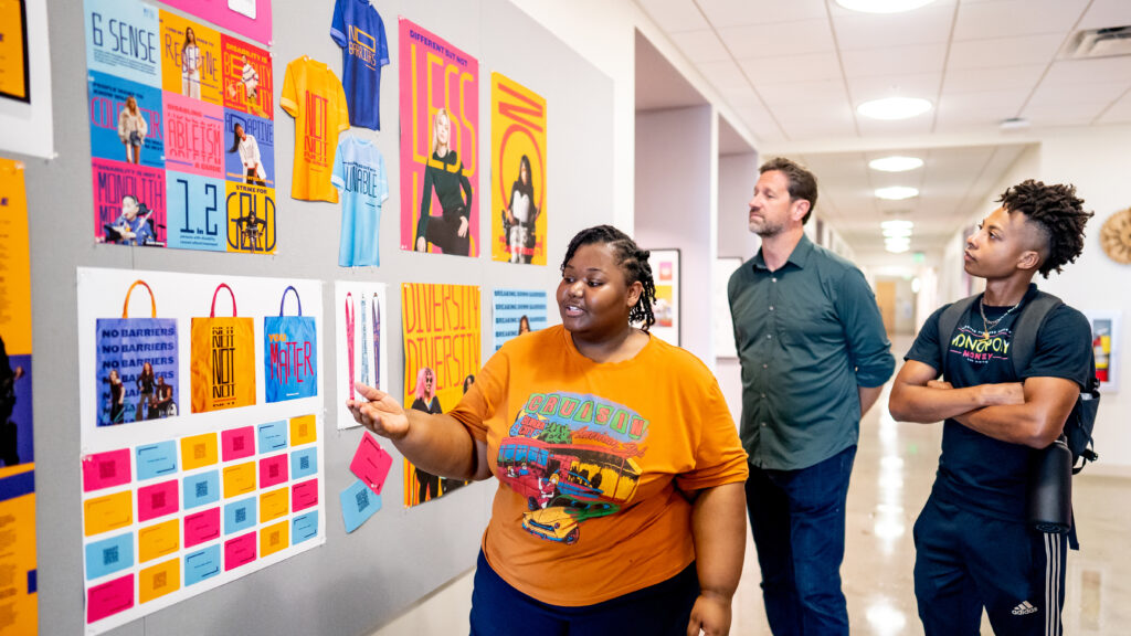 Students discussing work in the Graphic Design hallway.