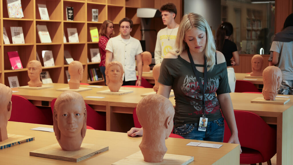 Booker High students explore the forensic sculptures inside the Special Collections reading room.